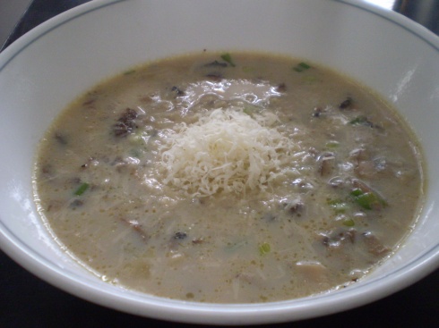 Mushroom and rice soup garnished with parmesan cheese.